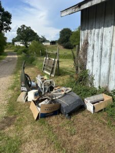 A pile of various junk items, including a vacuum, chair, and boxes, ready for removal by Junk Hawgs Removal and Rentals in Russellville, AR.