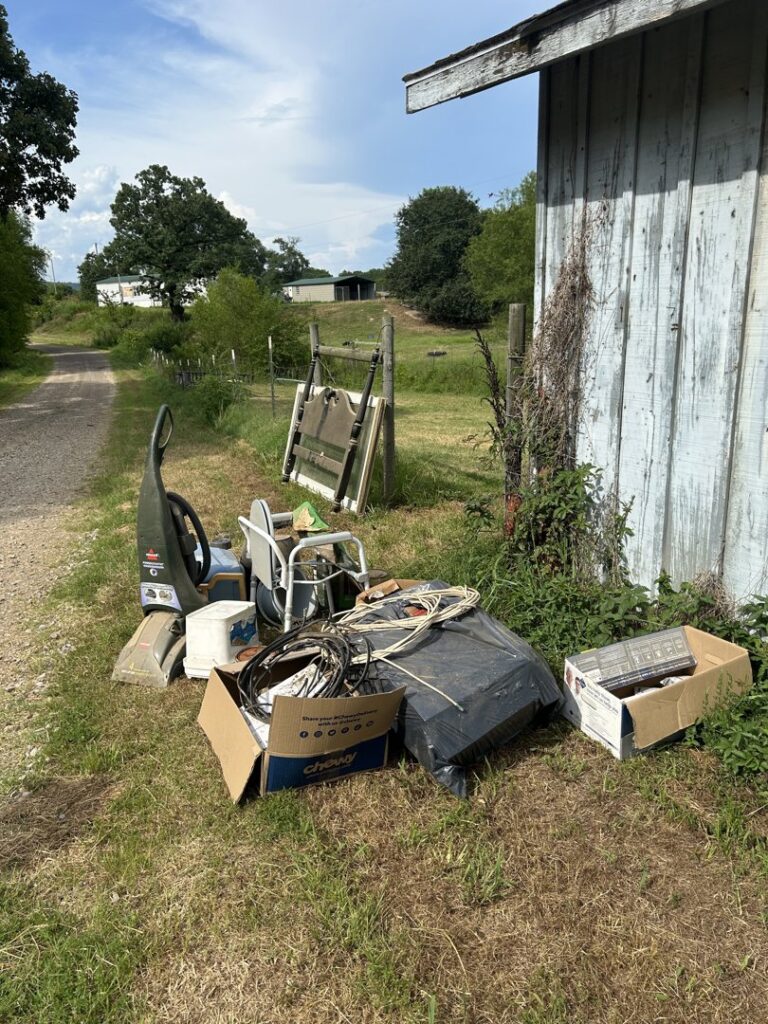 A pile of various junk items, including a vacuum, chair, and boxes, ready for removal by Junk Hawgs Removal and Rentals in Russellville, AR.