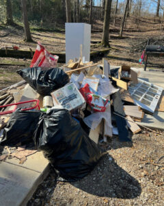 A large pile of junk, including a refrigerator, wood, and trash bags, on a patio, ready for junk removal by Curry Dumpster Rentals LLC in Southaven, MS.