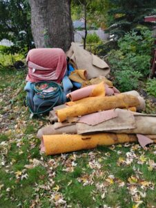 A pile of metal pipes, wood, and construction debris on a gravel surface before removal by One Call Junk Removal in Minneapolis, MN