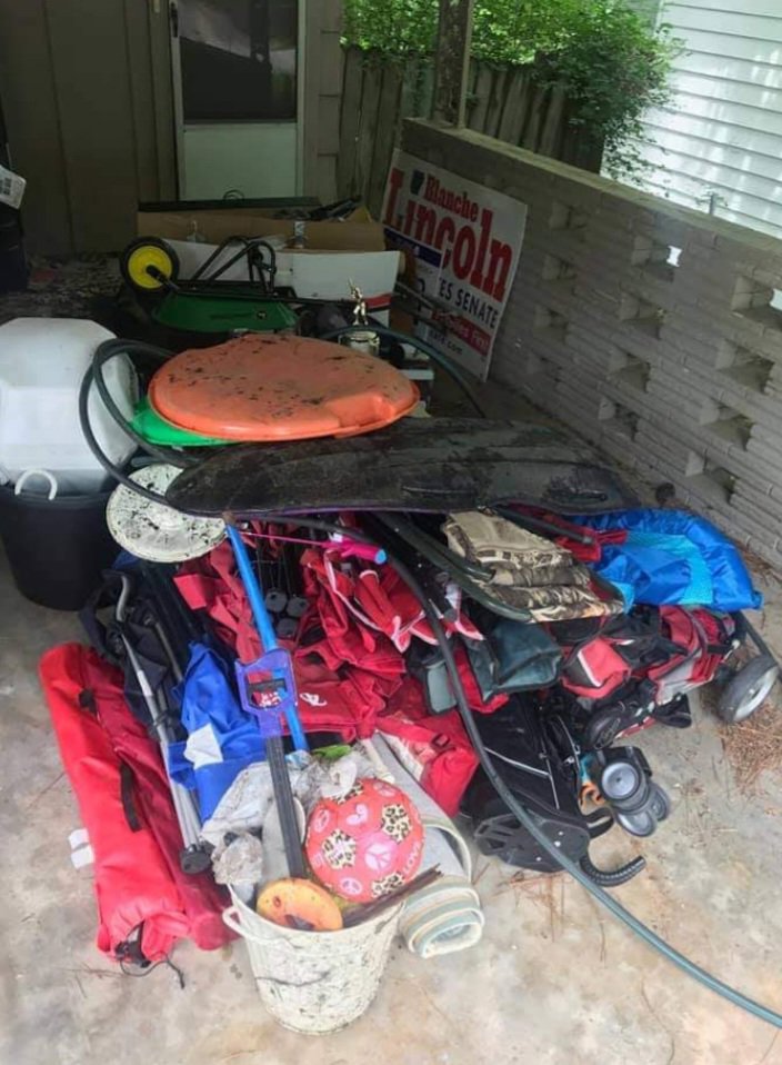 A pile of miscellaneous items, including a cooler and bags, on a patio, ready for junk removal by Urban Junk Removal, LLC in Springdale, AR.