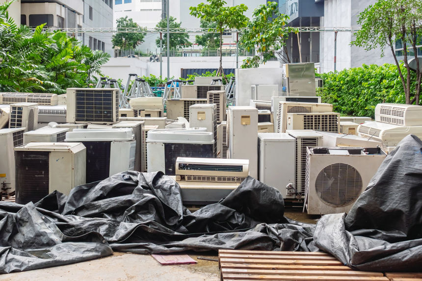 A large pile of old air conditioning units and scrap metal ready for recycling at RZR Mechanical LLC in Phoenix, AZ.