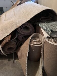 A close-up view of a large pile of rolled-up old carpets and various debris ready for junk removal in Columbus, OH.