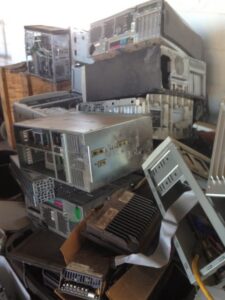 A large pile of old computer towers and other electronic waste, ready for removal and recycling by RZR Mechanical LLC in Phoenix, AZ.
