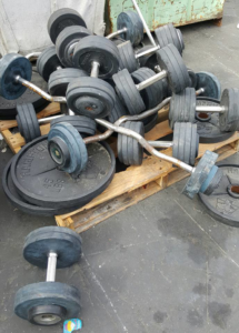 A pile of old dumbbells and weight plates ready for general junk removal by MIM Metal Recycling in Los Angeles, CA.