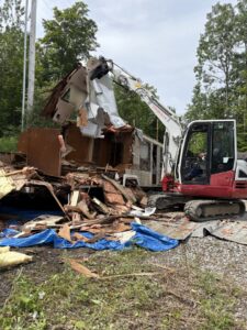 A large pile of old furniture and construction debris outside a building, ready for junk removal by Tiny's Trash & Hauling Service L.L.C in Williamstown, VT
