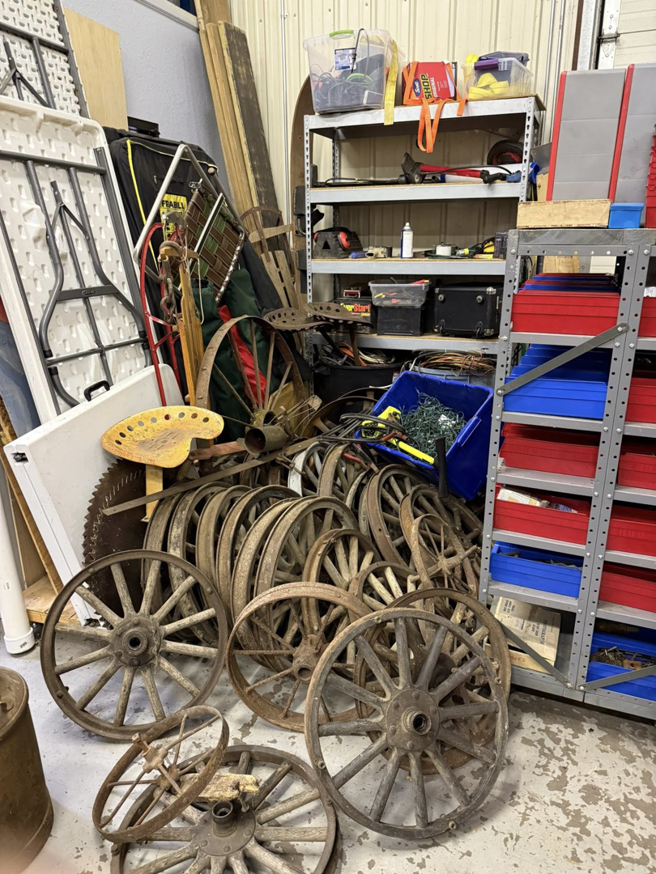 A large pile of old wooden wagon wheels and metal parts awaiting junk removal by Kersten Family Junk Removal in Eau Claire, WI.
