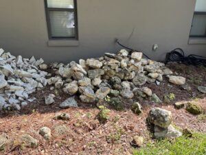 A pile of rocks and concrete debris next to a house, ready for general junk removal by DUMP 4 U Hauling in Jacksonville, FL.