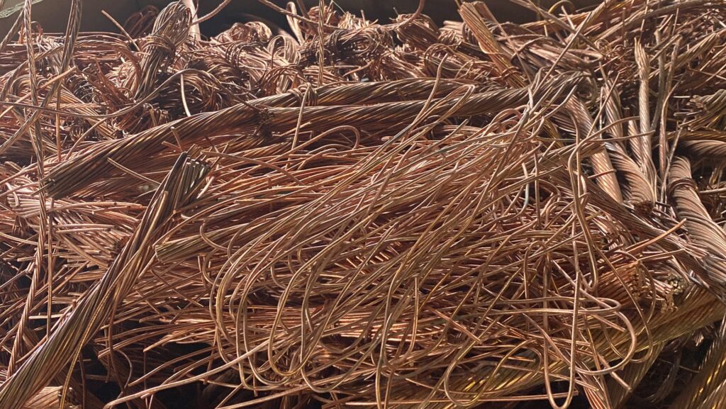 A close-up view of a large pile of tangled scrap copper wires at Queen City Metal Recycling & Salvage in Charlotte, NC.