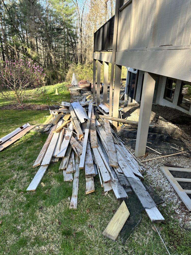A pile of wooden planks and construction debris on a lawn, ready for general junk removal by Top Tier Waste Services LLC in Lancaster, OH