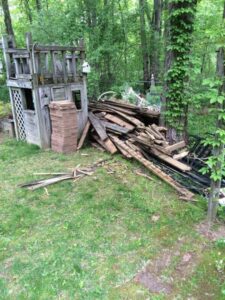 A large pile of wooden debris ready for removal by JDog Junk Removal & Hauling Capital Region NY in Schenectady, NY.