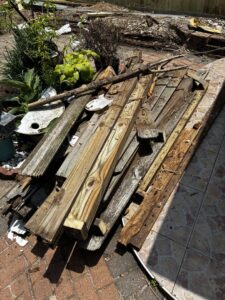 A pile of old wooden planks and construction debris on a patio, ready for Handymen Junk Removal in Houston, TX.