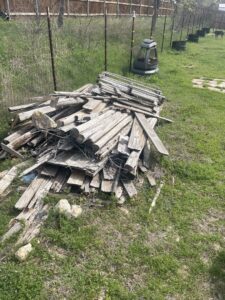 A large pile of old wooden planks and fencing material ready for junk removal by JB'S Junk Removal in Justin, TX.