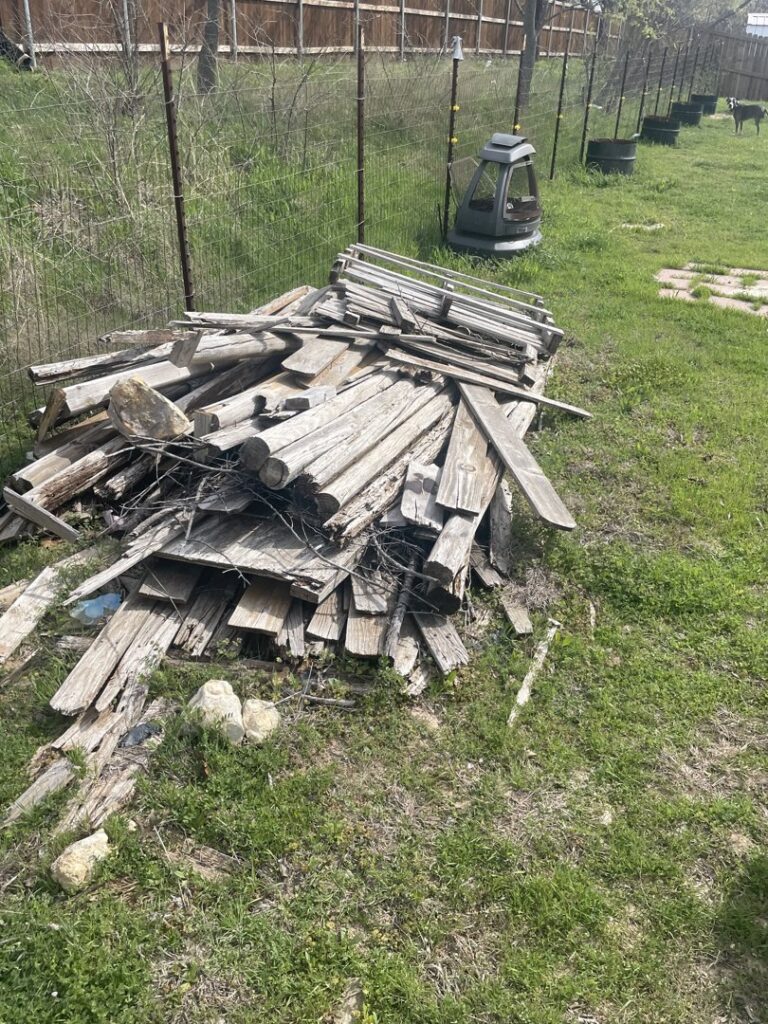 A large pile of old wooden planks and fencing material ready for junk removal by JB'S Junk Removal in Justin, TX.