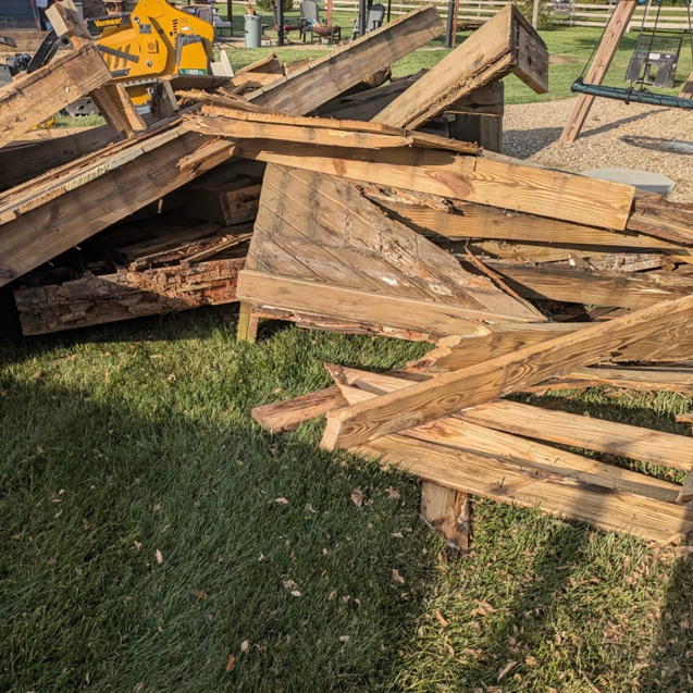 A large pile of wooden debris and demolition waste on a lawn for 5 Star Junk Removal, LLC in Elyria, OH