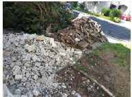 Piles of broken concrete and construction debris on the side of a driveway, ready for removal by DFW Service People in Dallas, TX.