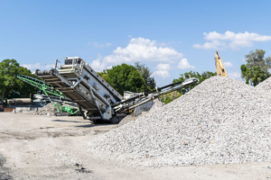 Piles of crushed aggregate and recycling equipment at Global Recycling of Tampa Bay in Tampa, FL.