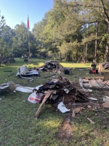 Two large piles of mixed debris including wood and metal, ready for junk removal by Reliable Pro in Tallahassee, FL.