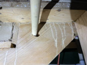 A pipe running through a wooden floor joist, showing an area that may require inspection or repair by AnderCall Professional Services LLC in Seaford, DE.