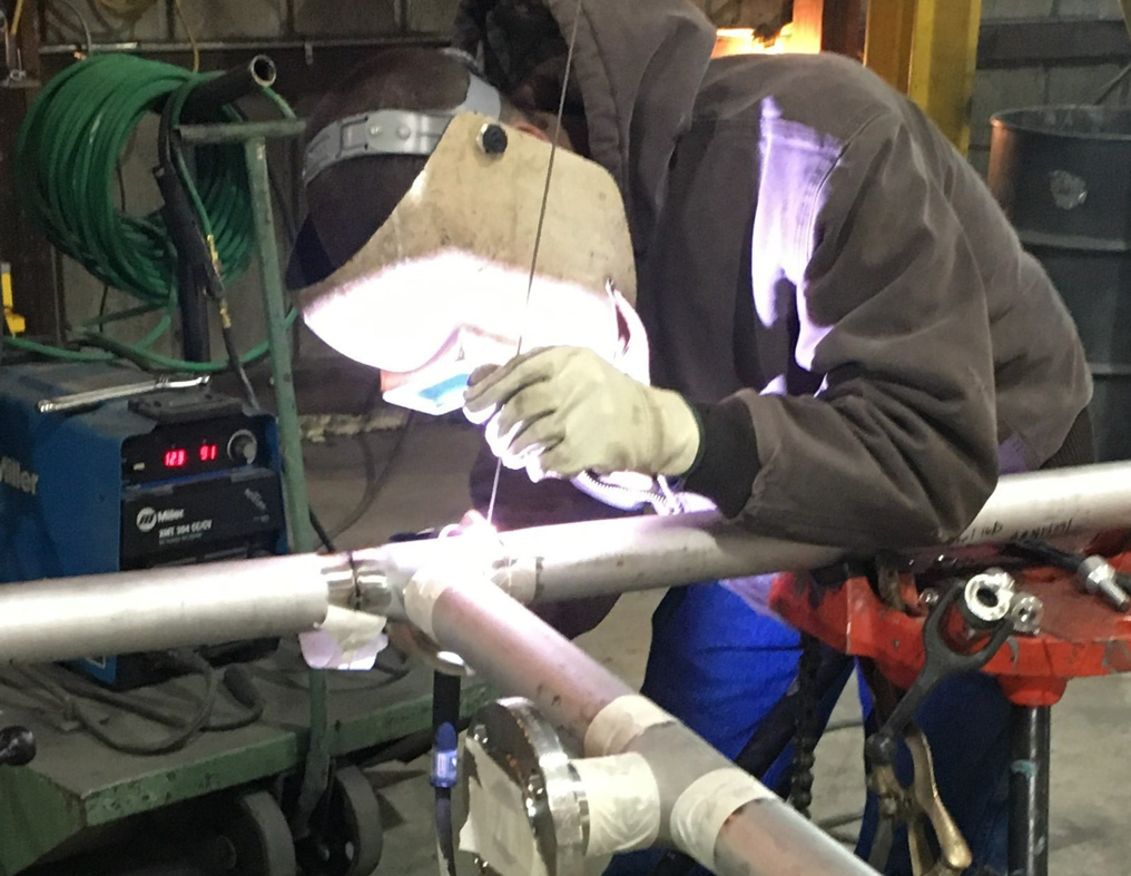 A worker performing pipe welding services at Accurity Industrial Contractors, Inc. in Owensboro, KY