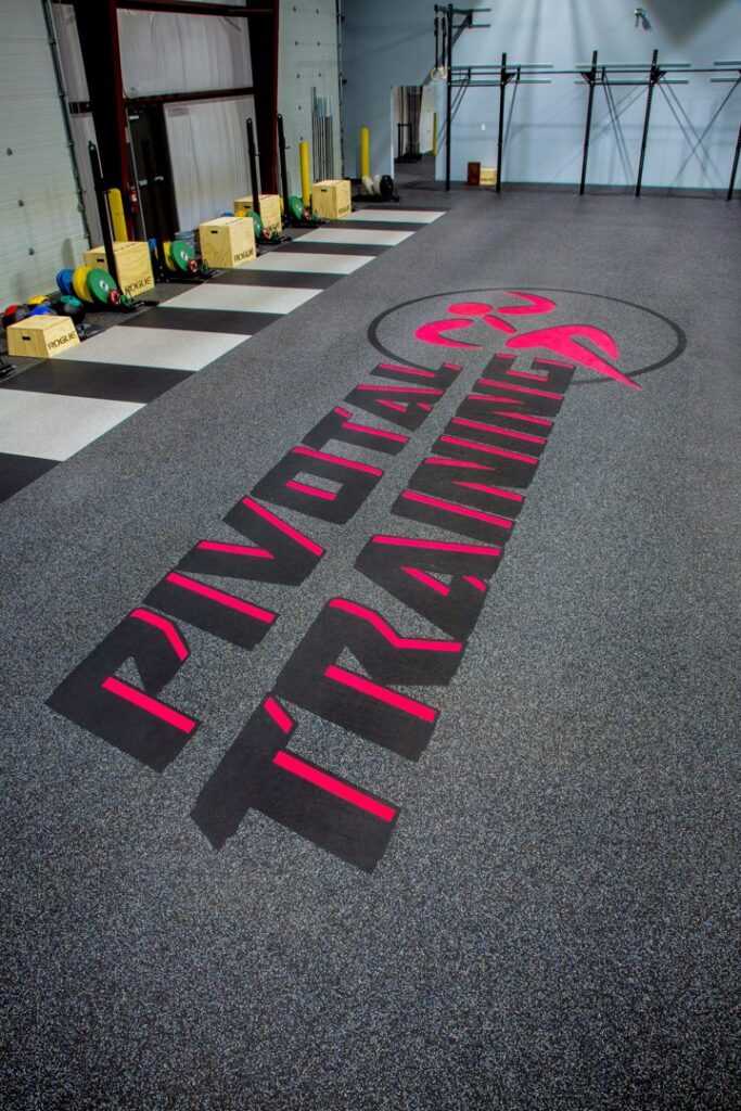 The custom floor with 'Pivotal Training' logo in an indoor gym facility installed by Abacus Sports Installations, Ltd in Lancaster, PA