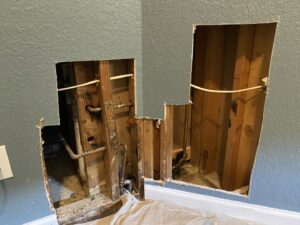 An opened wall revealing plumbing and electrical work during a repair or renovation by Elite Handyman & Remodeling in Dallas, TX.