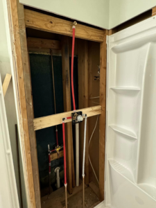 Exposed plumbing and framing for a shower rough-in installation by Tackett's Pro Trade Services in Berea, KY.