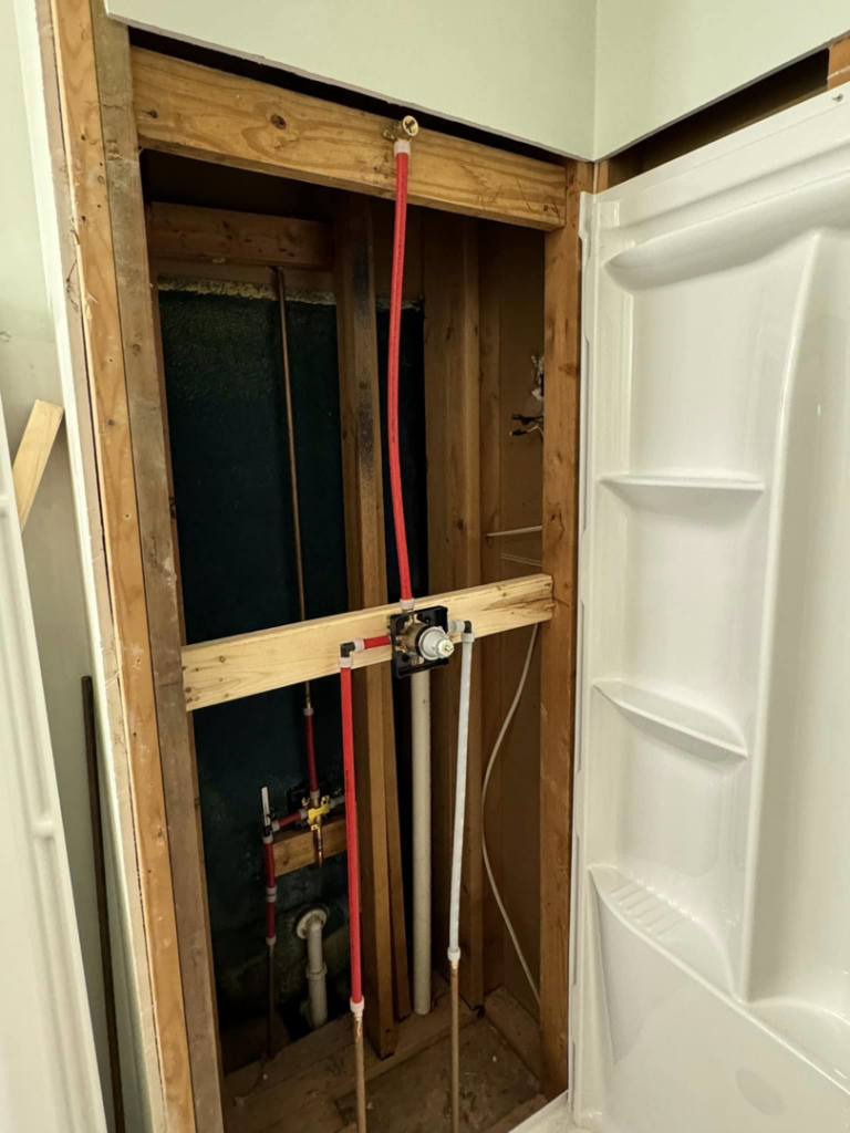 Exposed plumbing and framing for a shower rough-in installation by Tackett's Pro Trade Services in Berea, KY.