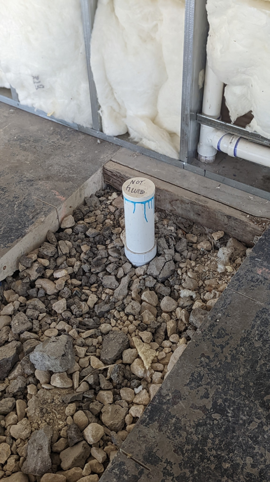 A plumbing pipe installed in the floor during a construction project by Rivera Services in Chandler, TX.