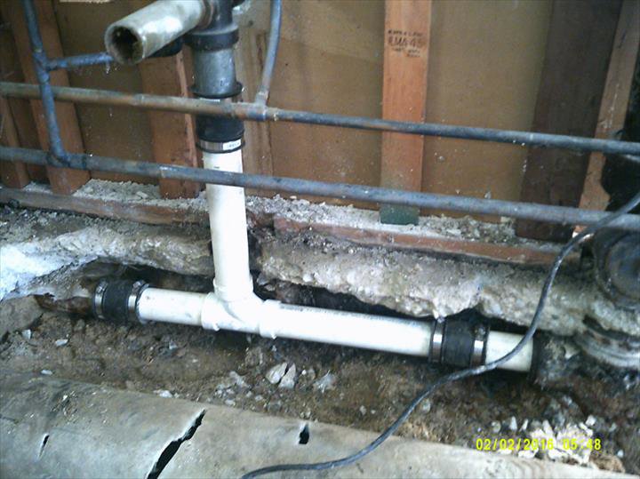 Plumbing pipes, including PVC and copper, exposed in a wall during a repair by Hessville Plumbing in Hammond, IN.