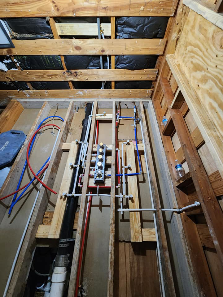 Extensive plumbing rough-in with a manifold system visible between exposed joists by AJAC Restore&Construct LLC in Houma, LA.