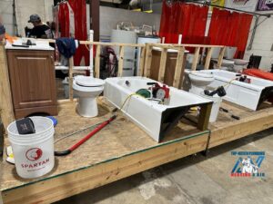 A plumbing training setup with bathtubs, toilets, and sinks at Top-Notch Plumbing, Heating & Air in Greeley, CO.
