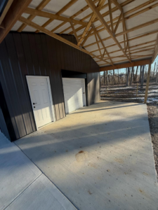 An interior and exterior view of a pole barn with a concrete floor and wooden roof trusses by Forward Construction in Florence, KY.