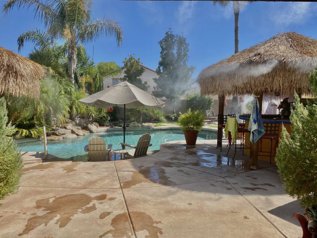 A high-quality mist system cooling a pool area with two tiki huts by Mr. Mister in Surprise, AZ