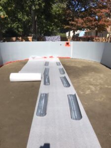 Insulation and padding being laid on the base of an above-ground pool during installation by Advanced Pools and Repair, LLC in Bristol, CT.