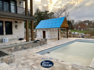 A new pool under construction with a partially built pool house and patio by Premier Pools & Spas - Cincinnati in Cincinnati, OH.