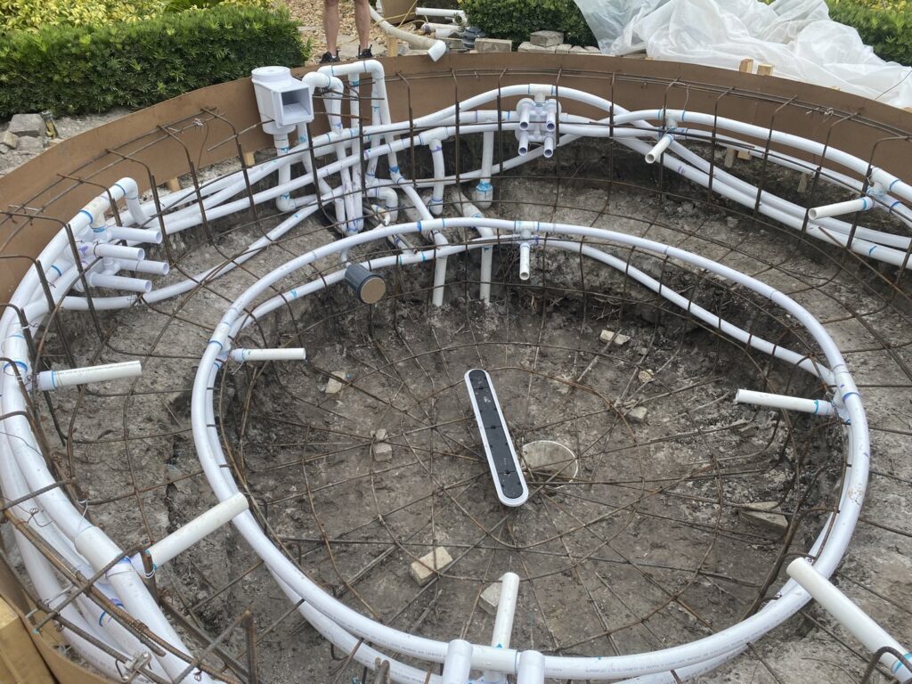 Pool construction in progress, showing rebar and plumbing lines being installed by JJB Pools & Spas in Tampa, FL.