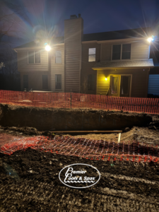 A pool excavation site with safety fencing and a house in the background by Premier Pools & Spas - Cincinnati in Cincinnati, OH.