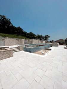 A large pool and hardscape area under construction, featuring brick walls and blue mosaic tiling, by Creative Pools and Hardscape in Franklin, TN.