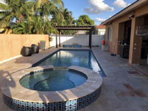 A newly installed swimming pool, spa, and wooden pergola, part of a general contracting project by BAFCO POOLS in Hialeah, FL.