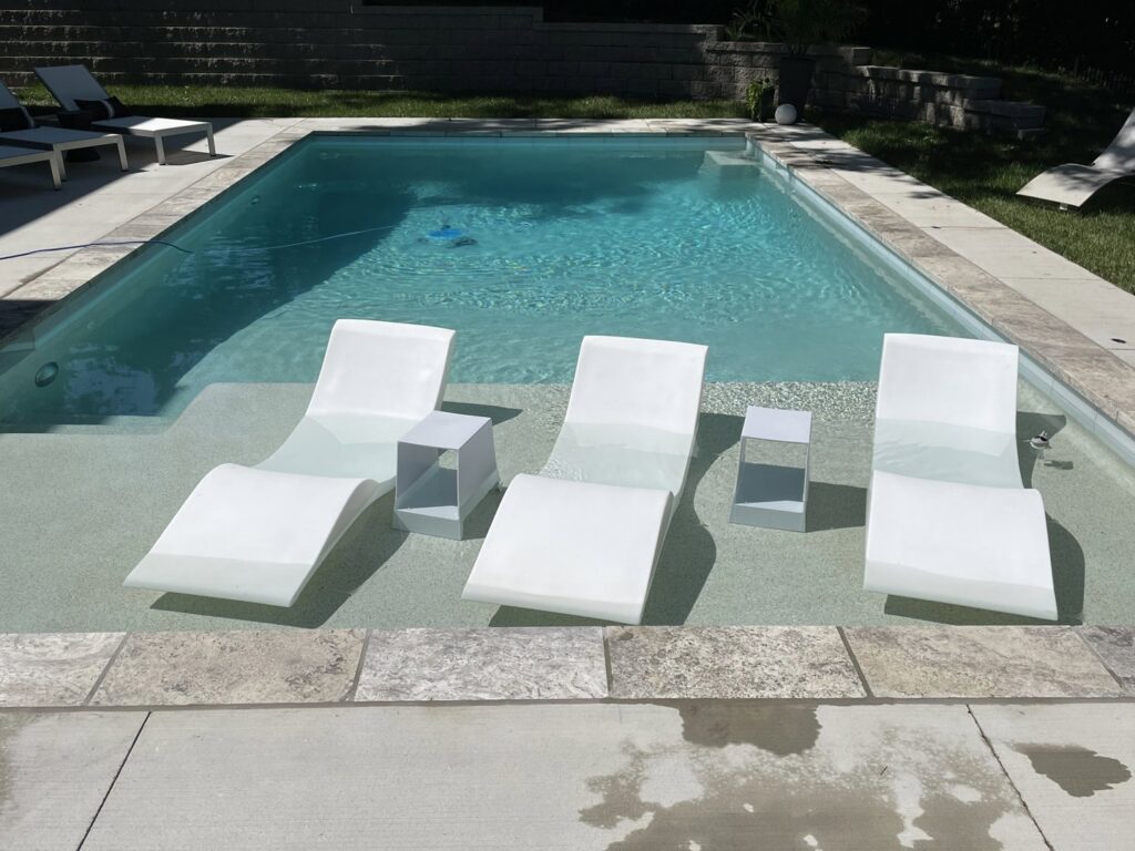 A beautiful pool with tanning ledges and in-pool lounge chairs by Elevate Pools in O'Fallon, MO.