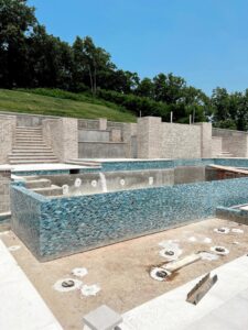 Close-up view of blue mosaic tiles being expertly installed on pool walls by Creative Pools and Hardscape in Franklin, TN.
