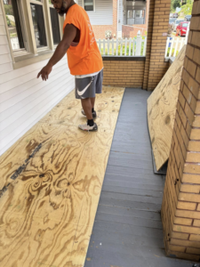 A worker installing plywood on a porch during a construction project by Ridgely Home Services LLC in Pittsburgh, PA.