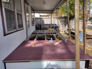 A porch deck under construction with framing visible and tools on the surface by Do-N-All Handyman Service in Wichita, KS.