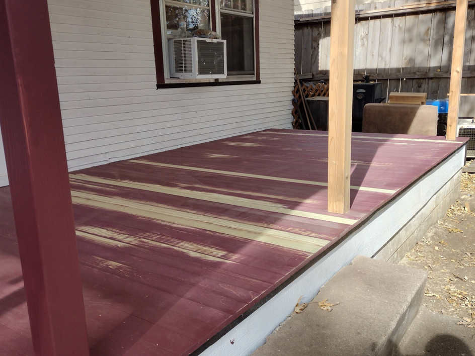 A porch deck undergoing renovation, partially sanded and stained, with new posts by Do-N-All Handyman Service in Wichita, KS.