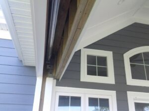Detail of porch eave construction with exposed framing and finished siding by The Home Pros in Carson, CA.