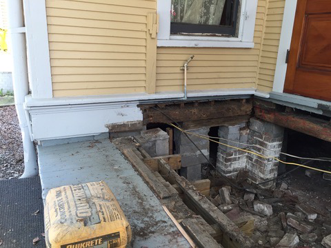 A porch foundation repair in progress with exposed supports and concrete mix in New Orleans, LA, by Richard Earls Construction.