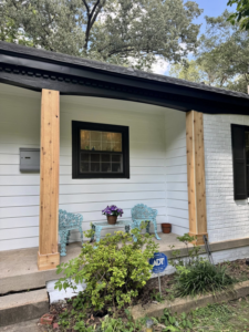 A newly renovated porch with new wooden columns and fresh paint by All Pro Roofing and Renovations in Sachse, TX.