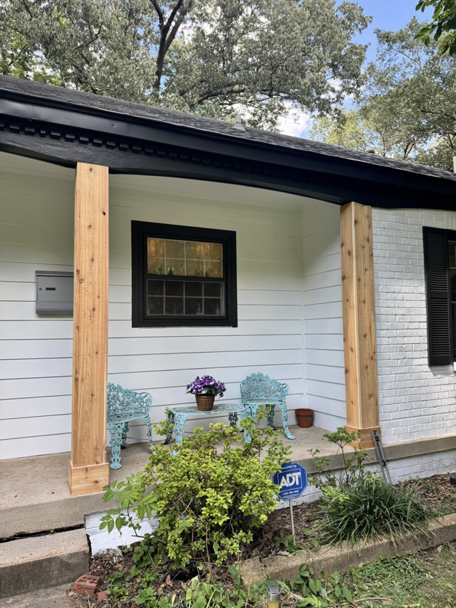 A newly renovated porch with new wooden columns and fresh paint by All Pro Roofing and Renovations in Sachse, TX.