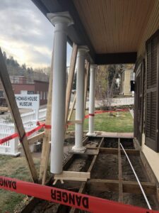 A porch undergoing renovation and repair work, with floorboards removed, by Deep Roots Craftsmen in Fort Collins, CO.